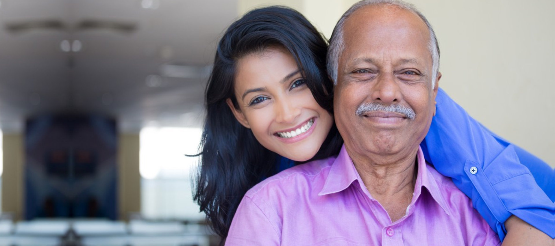 caregiver and senior man are smiling