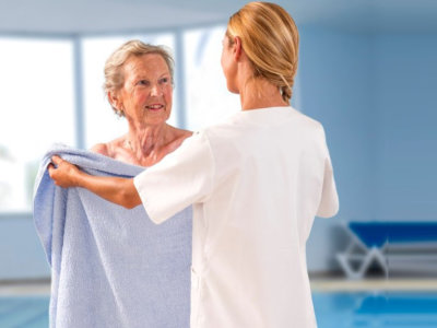 caregiver with elder woman by the poolside