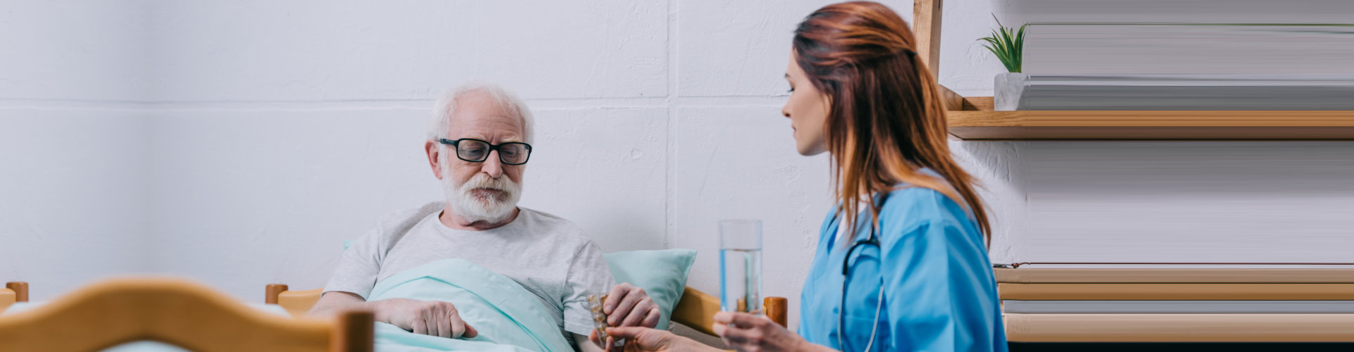 nurse giving medicine to the elderly man